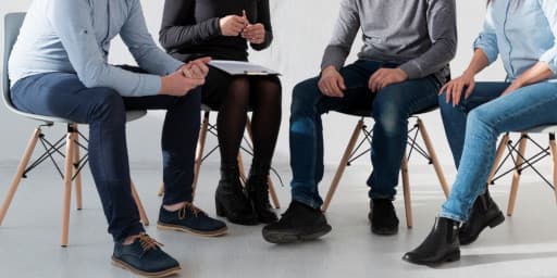 zdjęcie przedstawia kilka osób z terapeutką podczas sesji grupowej